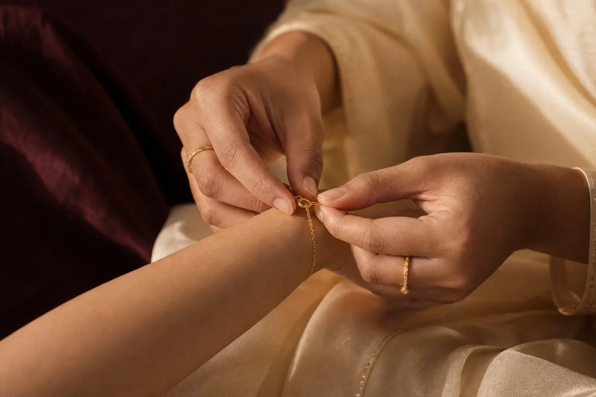 Hands fastening a delicate gold-toned bracelet